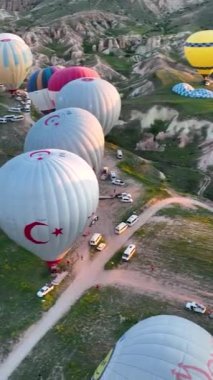 Sıcak hava balonları Kapadokya 'nın dağlık arazisinde uçuyor.