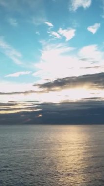 Bulutlu deniz günbatımı Güneşte uçuyor