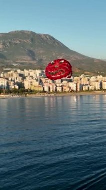 Su paraşütü denizdeki insanları kırmızı paraşütle gezdirir.