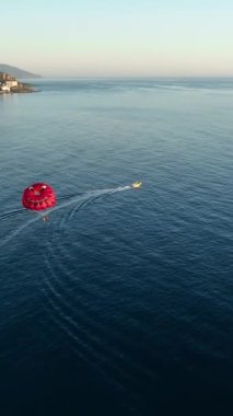 Su paraşütü denizdeki insanları kırmızı paraşütle gezdirir.