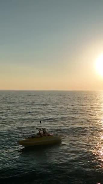 水上パラセーリングは海の赤いパラシュートで人々に乗る — ストック動画