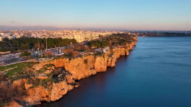 Mavi deniz ve liman kenti arka planıyla Alanya plajı dağ manzaralı.