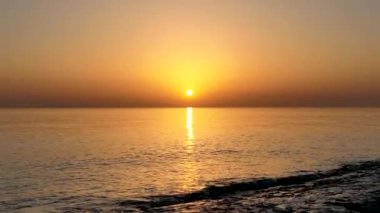 People sit on the beach and watch the sunset 4K
