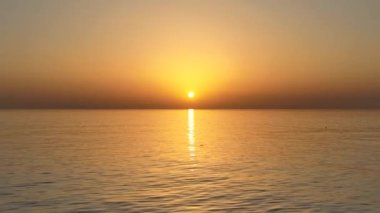 People sit on the beach and watch the sunset 4K