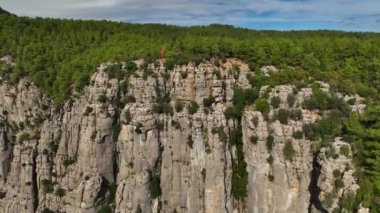 Tourist woman hiker on cliff against backdrop of gorge. Amazing Tazi Canyon, Turkey. Greyhound Canyon aerial view