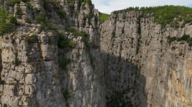 Tourist woman hiker on cliff against backdrop of gorge. Amazing Tazi Canyon, Turkey. Greyhound Canyon aerial view