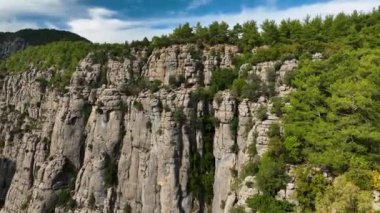 Tourist woman hiker on cliff against backdrop of gorge. Amazing Tazi Canyon, Turkey. Greyhound Canyon aerial view