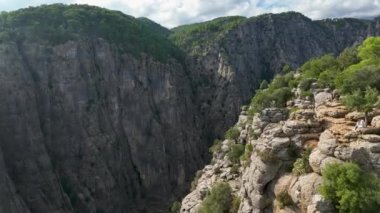 Tourist woman hiker on cliff against backdrop of gorge. Amazing Tazi Canyon, Turkey. Greyhound Canyon aerial view