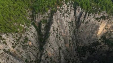 Tourist woman hiker on cliff against backdrop of gorge. Amazing Tazi Canyon, Turkey. Greyhound Canyon aerial view