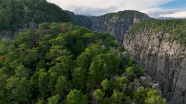 Tourist woman hiker on cliff against backdrop of gorge. Amazing Tazi Canyon, Turkey. Greyhound Canyon aerial view