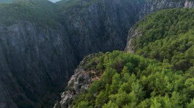 Tourist woman hiker on cliff against backdrop of gorge. Amazing Tazi Canyon, Turkey. Greyhound Canyon aerial view