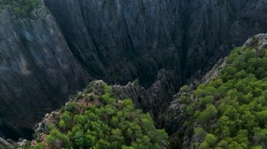 Tourist woman hiker on cliff against backdrop of gorge. Amazing Tazi Canyon, Turkey. Greyhound Canyon aerial view