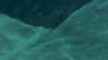 Aerial view azure sea draws patterns