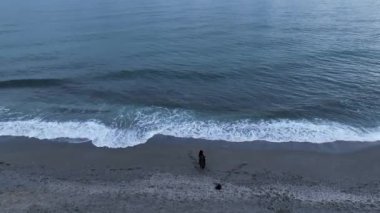 Elderly woman fishing in the sea, holds fishing rod and smiles. Family fishing trip in the open sea