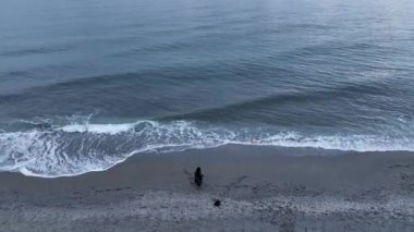 Elderly woman fishing in the sea, holds fishing rod and smiles. Family fishing trip in the open sea