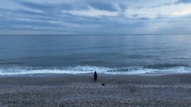 Elderly woman fishing in the sea, holds fishing rod and smiles. Family fishing trip in the open sea