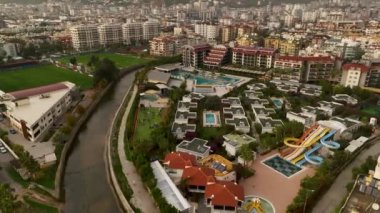 Strong rainbow above the city skyline over the houses and buildings in the daytime. The vivid phenomenon of nature. 4K