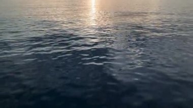 aerial view from drone at low altitude on sunset summer. Motion of small waves. Sea idyll. Relax 4 K