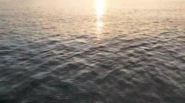 aerial view from drone at low altitude on sunset summer. Motion of small waves. Sea idyll. Relax 4 K