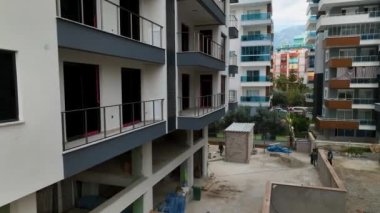Construction site on the shores of the Mediterranean Sea, Drone flies smoothly along the facade aerial view 4K