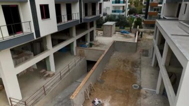 Construction site on the shores of the Mediterranean Sea, Drone flies smoothly along the facade aerial view 4K