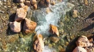 Water swiftly beats stones aerial view smooth frame 4 K