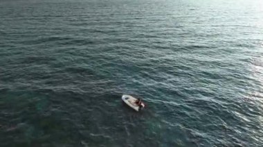 Old fisherman spreads his fishing nets in the sea, near the shore aerial view background