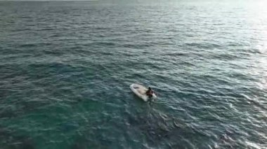 Old fisherman spreads his fishing nets in the sea, near the shore aerial view background