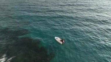 Old fisherman spreads his fishing nets in the sea, near the shore aerial view background