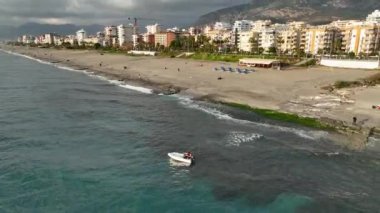 Old fisherman spreads his fishing nets in the sea, near the shore aerial view background