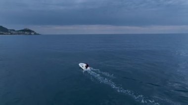 The fisherman listens to music in white headphones and catches fish