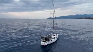 Hava görüntüleri, derin mavi bir denizde seyreden lüks yelkenli görüntüsü.