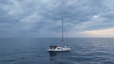 Hava görüntüleri, derin mavi bir denizde seyreden lüks yelkenli görüntüsü.