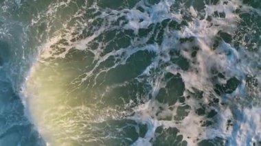 Kuş bakışı okyanus mavisi dalgalar yavaş çekimde çarpıyor.