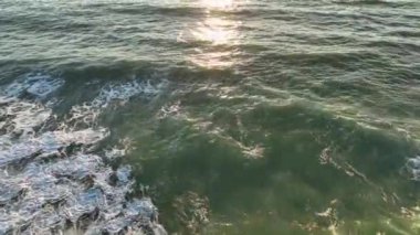 Mavi deniz güzelliğiyle hipnotize eder okyanus dalgası beyaz köpükle ağır çekimde.