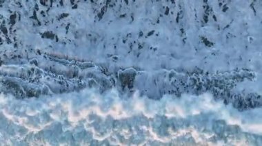 Güneşli bir günde yeşil deniz suyunda parlayan ve yansıtan güçlü dalgaların havadan görünüşü.
