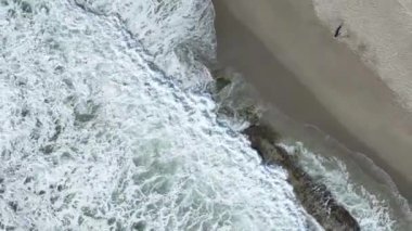 Kumlu kumsalda güzel deniz dokusu köpüklü suyla gök mavisi dalgalar,