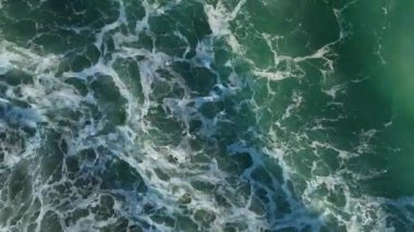 Kumlu kumsalda güzel deniz dokusu köpüklü suyla gök mavisi dalgalar