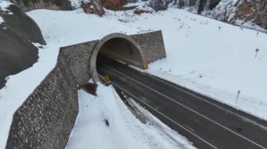 Soğuk kış gününde manzaralı karlı orman. Kışın harikalar diyarı dağ manzarasında şiddetli kar fırtınasında uçan insansız hava aracı.