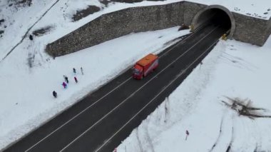 Bulutlu bir günde karla kaplı ağaçların üzerinde uçmak ikonik bir kış manzarası verir.