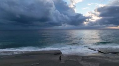 Çift ayakta ve en tatlı sevgililer gününde sarılıyor deniz dalgalarının kış titreşimlerini yakalıyor