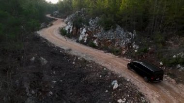 Hava takibi, güneşli bir günde ormanda yetişen yemyeşil ağaçların arasında gerçek zamanlı bir araba görüntüsü verdi.