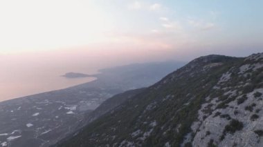 Şehir manzarasına tepeden bakan bir dağın arkasından kalkış.