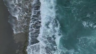 Kamera suyun üzerinde uçuyor, su yüzeyinin görüntüsü yukarıdan aşağıya mavi mavi mavi turkuaz deniz suyu dokusunun yüksekliğinden görünüyor..