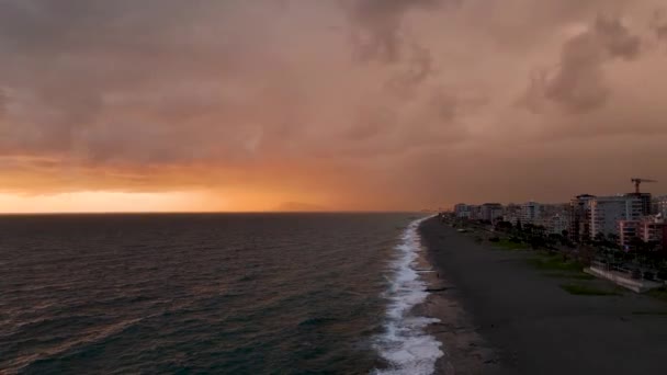 海でロマンチックなカラフルな夕日 海を背景に 太陽は沈み 青い雲とオレンジ色の雲が空を流れます 雄大な春の風景 日没の風景時間の経過 — ストック動画