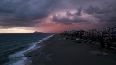 Deniz yüzeyindeki küçük dalgalar, güneşin yavaş çekim pembe günbatımına karşı havadan görüntülü drone 'lar. Büyük bir güneş diski denizin üzerinde yükselir, güneş yolu da suyun üzerinde. Deniz manzarasının altın ışığı. Rahat ol. Doğa. Özgürlük