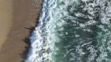 Mutlu gençler, güneşli bir günde Türk sahillerinde dalgalarda yuvarlanarak eğleniyorlar.