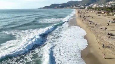 Sinematik Akdeniz 'de. Kumsaldaki hava manzarası ve insanlar. Tatil ve macera. Kumsal ve mavi su.