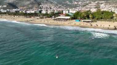 Hava görüntüsü: Turkuaz su üzerinde kürek çeken bir adam. Türkiye 'de tatilde olan insanlar sinematik çekim yapıyor