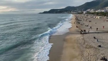 Sinematik Akdeniz 'de. Kumsaldaki hava manzarası ve insanlar. Tatil ve macera. Kumsal ve mavi su.